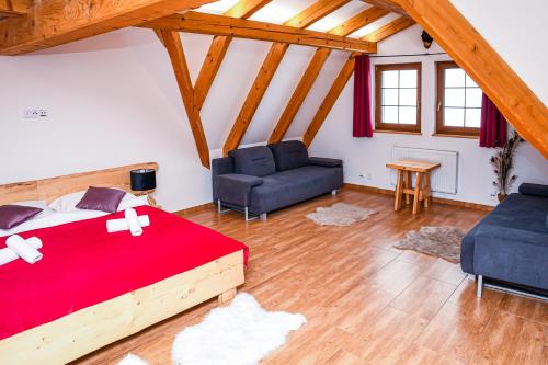 a bedroom with a bed and two chairs and a couch at Chata Emil Zatopek - Maraton - Lysa Hora in Krásná