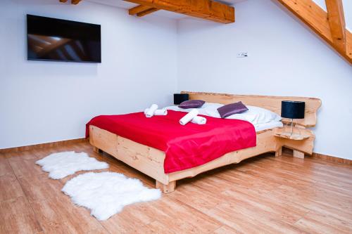 a bedroom with a bed with red sheets and white towels at Chata Emil Zatopek - Maraton - Lysa Hora in Krásná