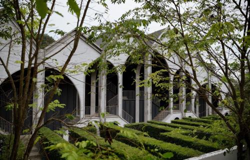 a white house with a bunch of trees at Hotel Labaris Khao Yai in Mu Si