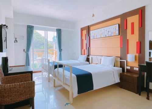 a bedroom with two beds and a large window at 華納小筑 in Kenting