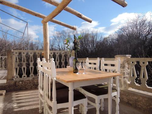 Une table et des chaises en bois sont disponibles sur la terrasse. dans l'établissement Apartment Pink Mimosa, à Malinska