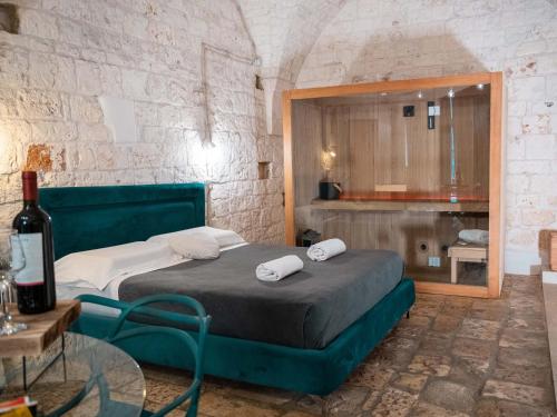 a bedroom with a bed and a table with a bottle of wine at Dama Bianca Boutique Hotel Ostuni in Ostuni