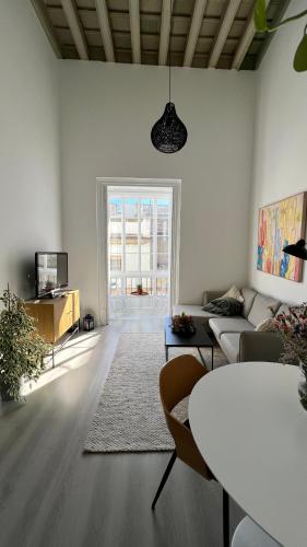 a living room with a couch and a table at Apartamento Duplex casa Palacio rehabilitado centro El Puerto in El Puerto de Santa María
