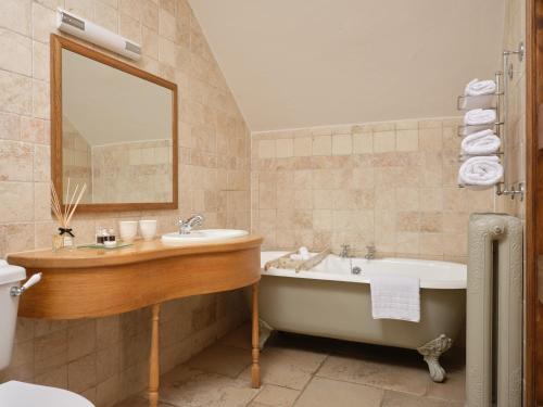 a bathroom with a tub and a sink and a bath tub at The Newbridge on Usk in Usk