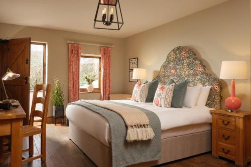a bedroom with a large bed with a large headboard at The Newbridge on Usk in Usk