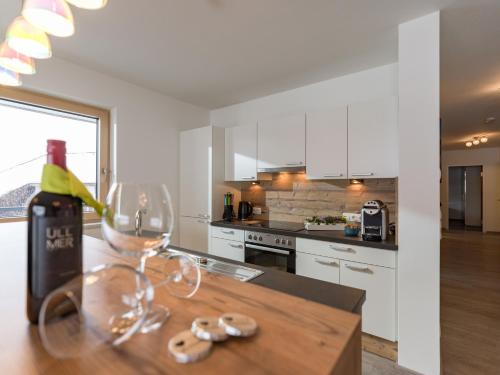 a kitchen with a bottle of wine and glasses on a table at Ledermaier Loft & Lodge`s eU in Achenkirch