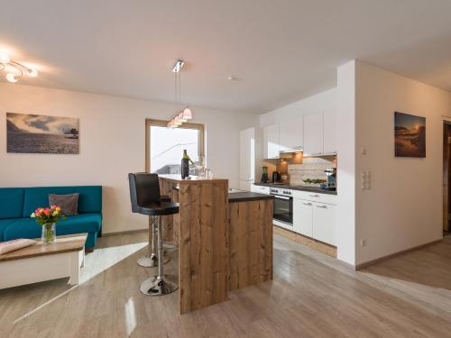 an open kitchen and living room with a blue couch at Ledermaier Loft & Lodge`s eU in Achenkirch