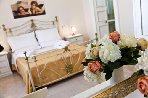 a bedroom with a bed with flowers on a table at Palazzo Volta Boutique Luxury B&B in Nardò