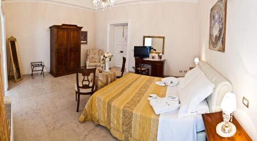 a bedroom with a bed and a desk and a television at Palazzo Volta Boutique Luxury B&B in Nardò