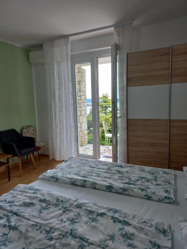 a bedroom with a bed and a view of the ocean at Apartments & Rooms Karmen in Portorož