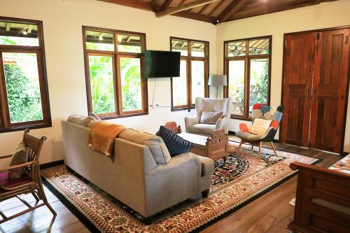 uma sala de estar com um sofá e duas cadeiras em The Lodge Maribaya em Lembang