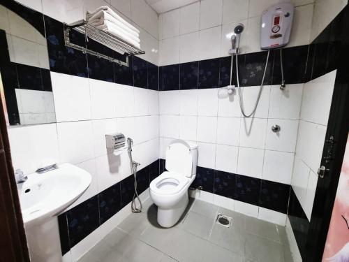 ein Bad mit einem WC und einem Waschbecken in der Unterkunft Hotel Sun Birds in Cameron Highlands