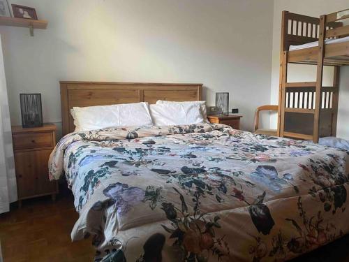 a bedroom with a bed with a floral comforter at Villa Rosa Perla - Lake Como - Schignano in Schignano