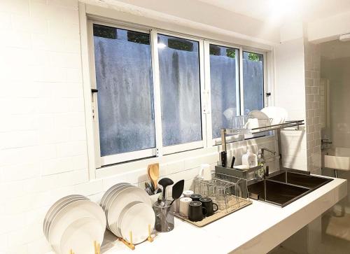 a kitchen with a sink and some windows at River Home Bangkok in Bangkok