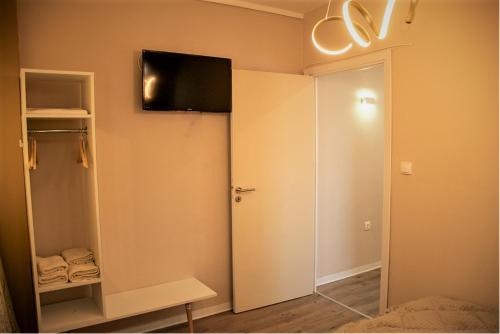 sypialnia z przesuwnymi drzwiami i telewizorem na ścianie w obiekcie JuKeBoX Suite 2 BEDROOMS - BIG BALCONY w Salonikach