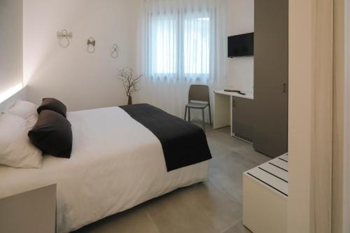 1 dormitorio con cama, escritorio y cocina en Alloggi alla Rotonda 