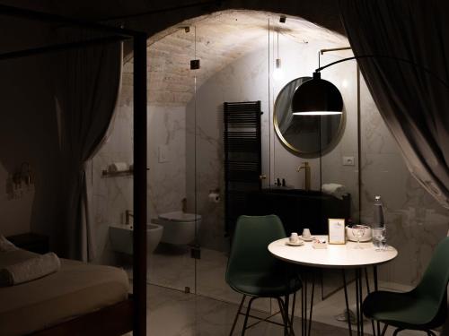 a room with a table and a bathroom with a shower at Dama Bianca Boutique Hotel Ostuni in Ostuni