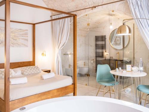 a bedroom with a bed and a table and a tub at Dama Bianca Boutique Hotel Ostuni in Ostuni