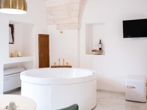 a white bathroom with a large white tub in it at Dama Bianca Boutique Hotel Ostuni in Ostuni