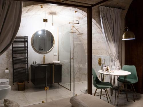 a bathroom with a shower and a table and a mirror at Dama Bianca Boutique Hotel Ostuni in Ostuni