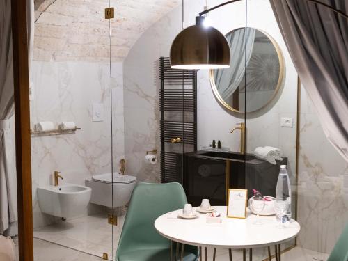 a bathroom with a table and a sink and a mirror at Dama Bianca Boutique Hotel Ostuni in Ostuni