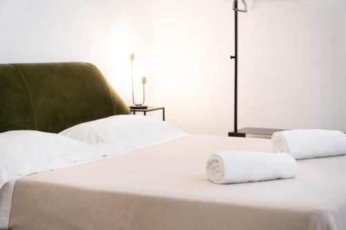 a white bed with two rolled towels on it at Dama Bianca Boutique Hotel Ostuni in Ostuni