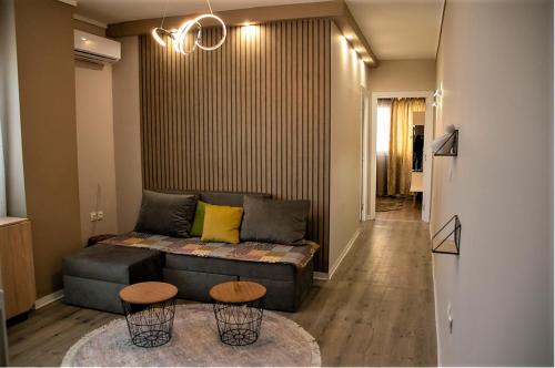 salon z kanapą i 2 stołkami w obiekcie JuKeBoX Suite 2 BEDROOMS - BIG BALCONY w Salonikach
