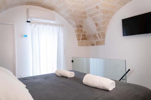 a bedroom with a bed with two towels on it at Dama Bianca Boutique Hotel Ostuni in Ostuni