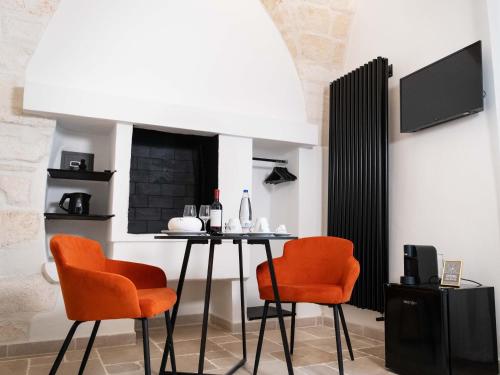 a dining room with a table and two orange chairs at Dama Bianca Boutique Hotel Ostuni in Ostuni