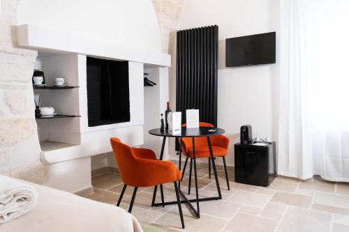 a dining room with a table and orange chairs at Dama Bianca Boutique Hotel Ostuni in Ostuni