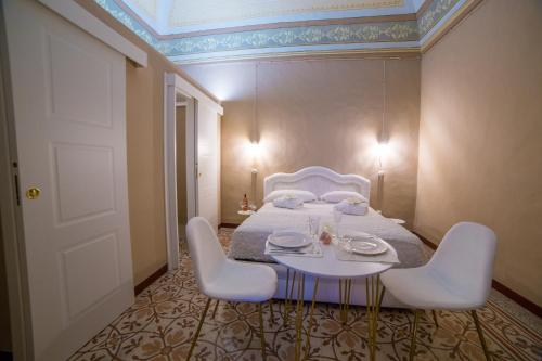 a bedroom with a bed with a table and chairs at Dama Bianca Boutique Hotel Ostuni in Ostuni