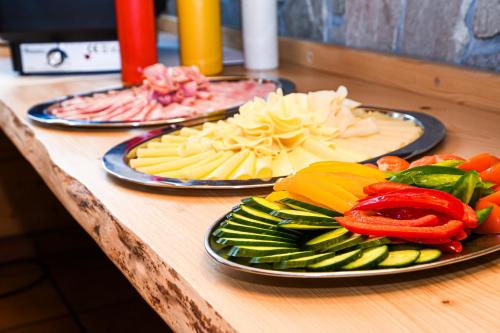 three plates of food on a wooden counter top at Chata Emil Zatopek - Maraton - Lysa Hora in Krásná