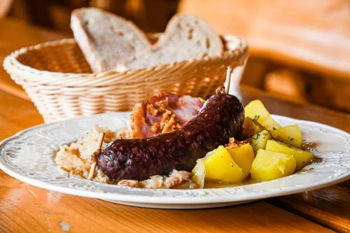 a plate of food with a sausage and potatoes on a table at Chata Emil Zatopek - Maraton - Lysa Hora in Krásná