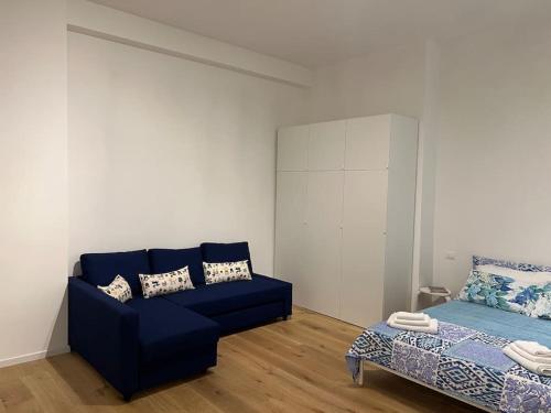un soggiorno con divano blu e letto di Monolocale nel cuore di Genova a Genova
