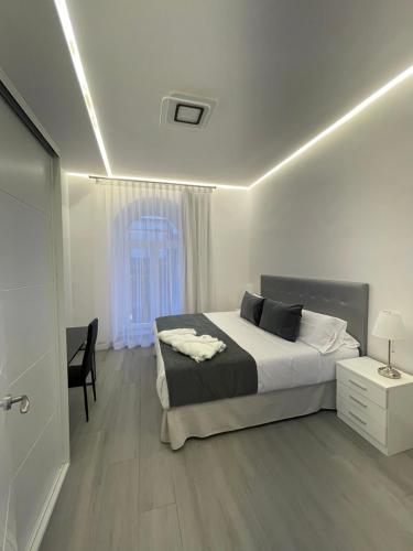 a bedroom with a bed and a chair and a window at SUARA Apartamentos 1 in Madrid