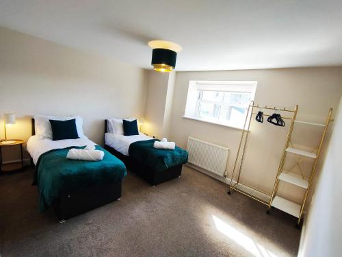 ein kleines Zimmer mit 2 Betten und einem Fenster in der Unterkunft Freedom Hall Apartment in Queensbury