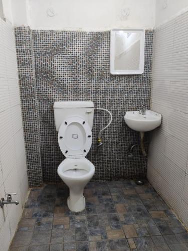 a bathroom with a toilet and a sink at HOTEL SUKHMANI in Guwahati