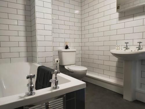 Freedom Hall Apartment في Queensbury: حمام ابيض مع مرحاض ومغسلة