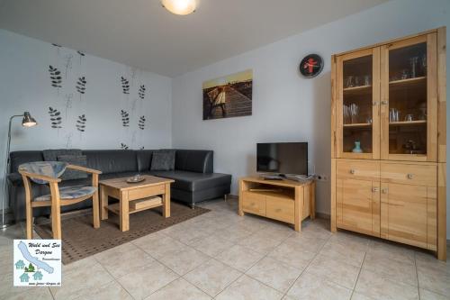 ein Wohnzimmer mit einem Sofa und einem Tisch in der Unterkunft Wald und See Dargun 31A in Dargun