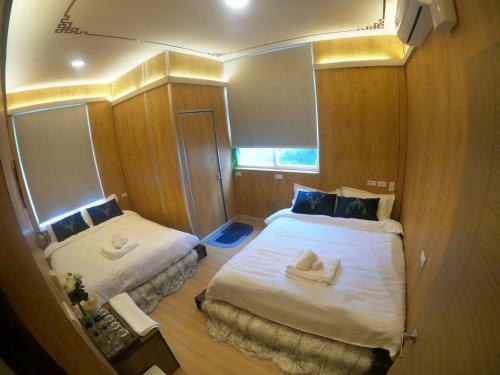 a small room with two beds and a mirror at 20ft Sea Attic in Green Island