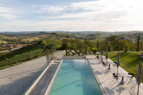 a swimming pool with a view of the rolling hills at Ca' del Profeta Ristorante & Relais in Montegrosso dʼAsti
