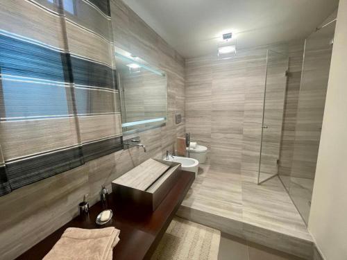 ein Bad mit einer Badewanne, einem Waschbecken und einer Dusche in der Unterkunft Villa I tre Cipressi in Lido di Camaiore