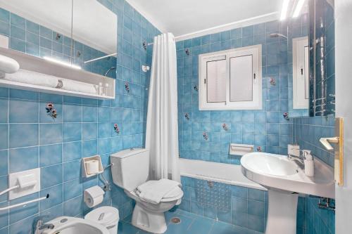 uma casa de banho em azulejos azuis com um WC e um lavatório em Apartamentos Tamara em Tacoronte