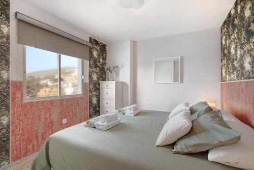 um quarto com uma cama grande e uma janela em Apartamentos Tamara em Tacoronte