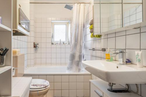 a bathroom with a tub and a sink and a toilet at Private Apartment Smoker in Hannover
