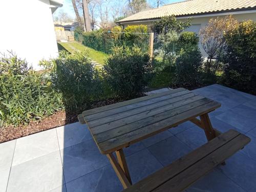 un banc en bois installé au-dessus d'une terrasse dans l'établissement Jolie petite maison, à Sanguinet