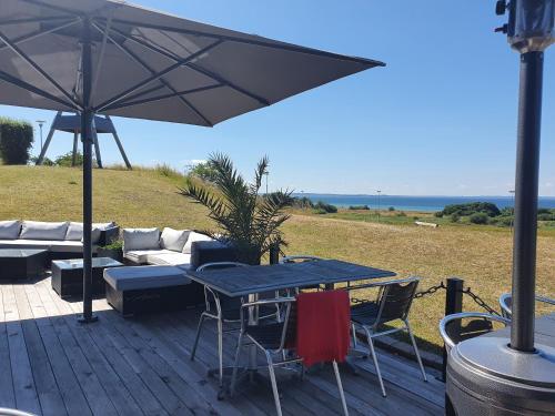 a wooden deck with a table and an umbrella at Sundsgården hotell & konferens in Helsingborg