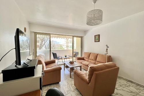 Il comprend un salon doté d'un mobilier en cuir brun et d'une télévision à écran plat. dans l'établissement Bright and quiet apartment near the sea, à Saint-Raphaël