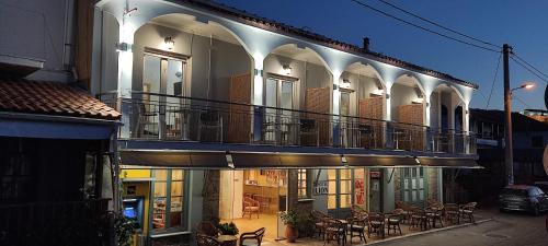 een gebouw met een balkon met tafels en stoelen bij Hotel Ilion in Petra