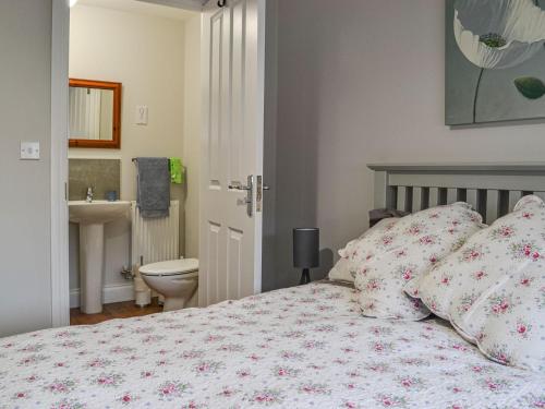 a bedroom with a bed and a toilet and a sink at Lapwing Lodge in New Hunstanton